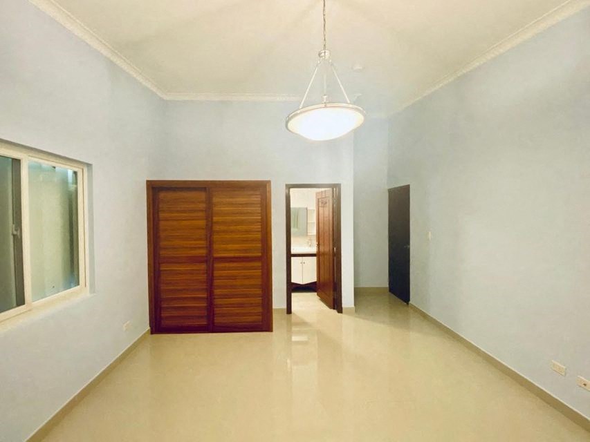 an empty room with a wooden door and a light