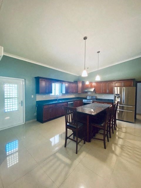 a large kitchen with a table and a refrigerator