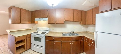 an empty kitchen with wooden cabinets and white appliances