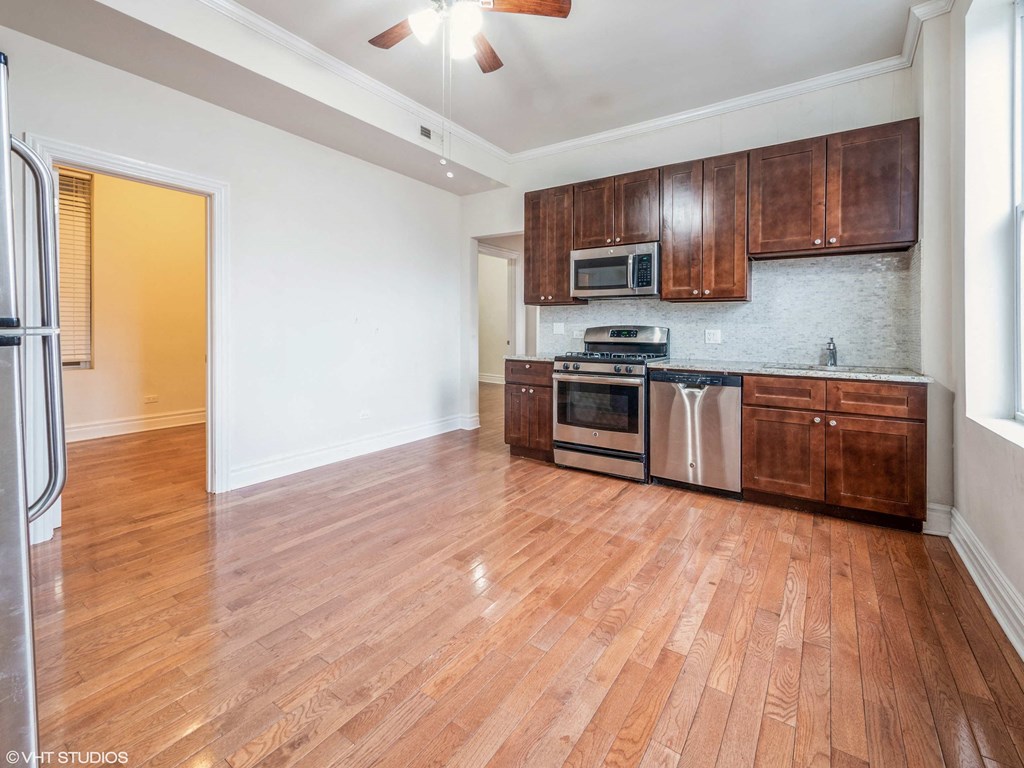 an empty kitchen with wooden cabinets and stainless steel appliances