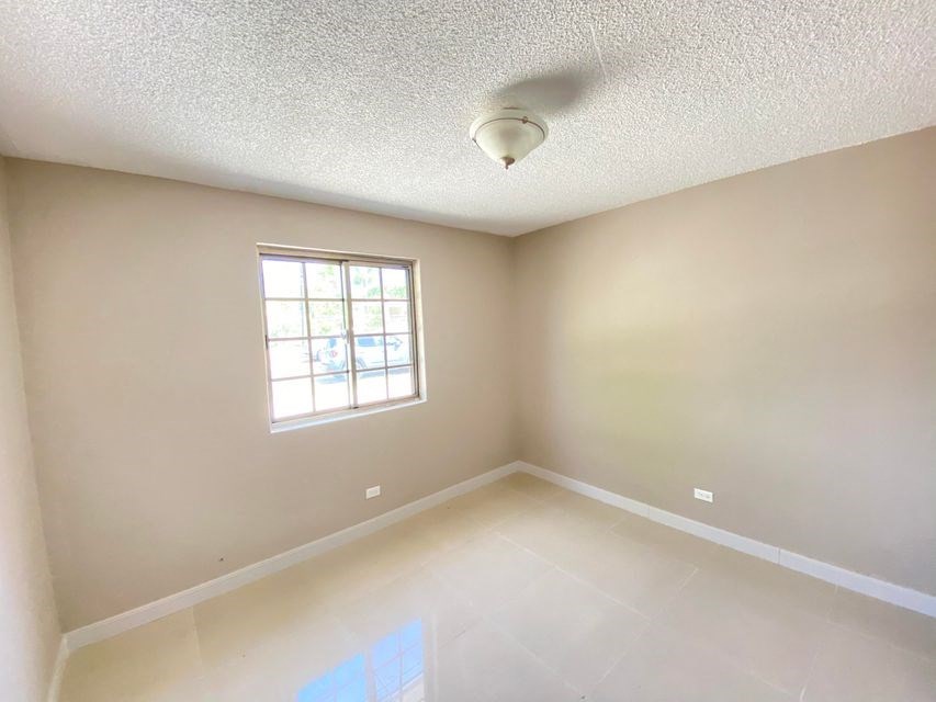 an empty room with a window and a ceiling fan