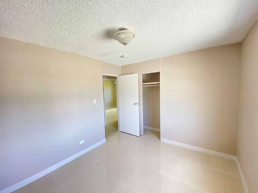 an empty room with a door to a closet and a ceiling light