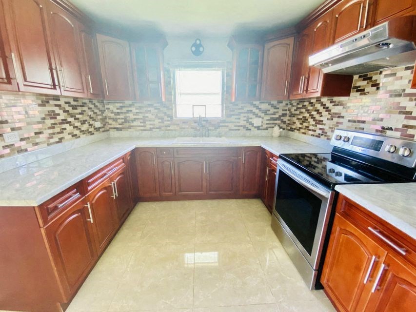 a kitchen with wooden cabinets and a stove and a window