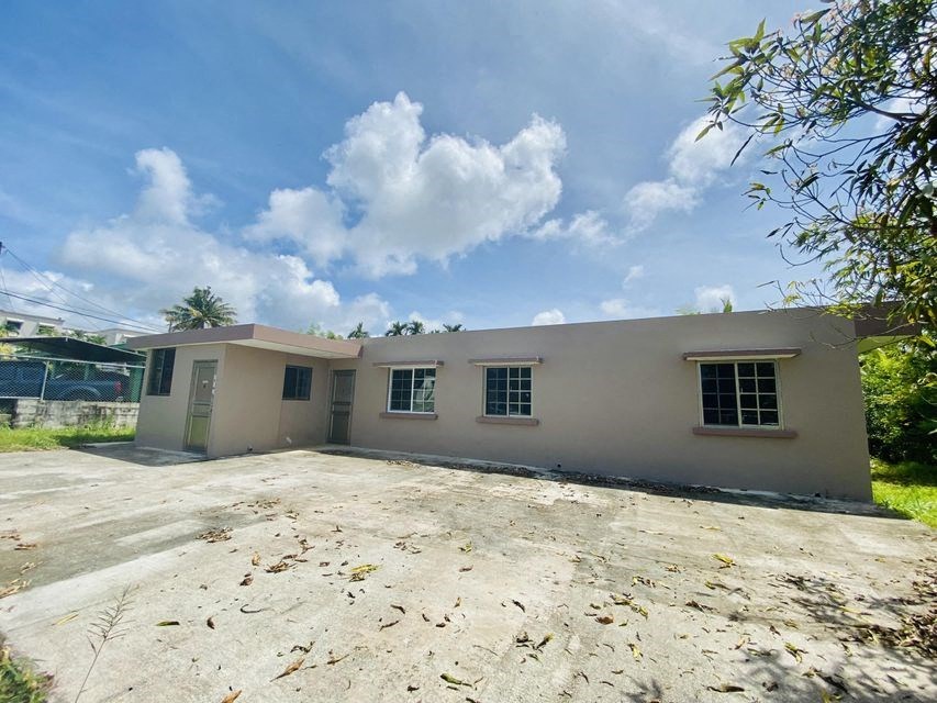 a small house with a dirt yard in front of it