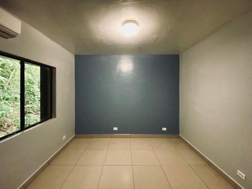 a empty room with a blue wall and a large window