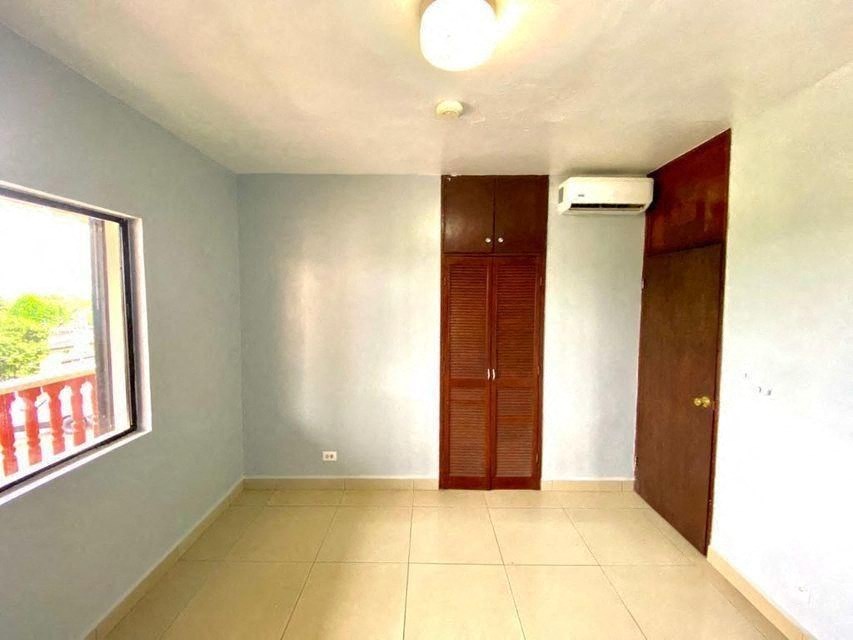 an empty living room with a large window and a wooden door