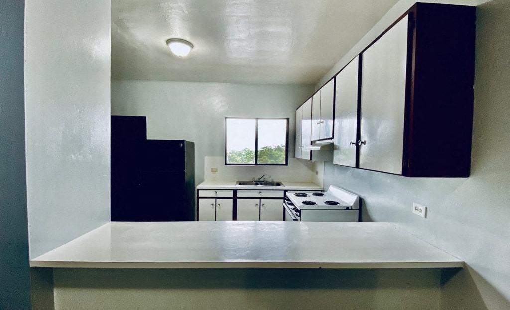 an empty kitchen with a stove and a sink