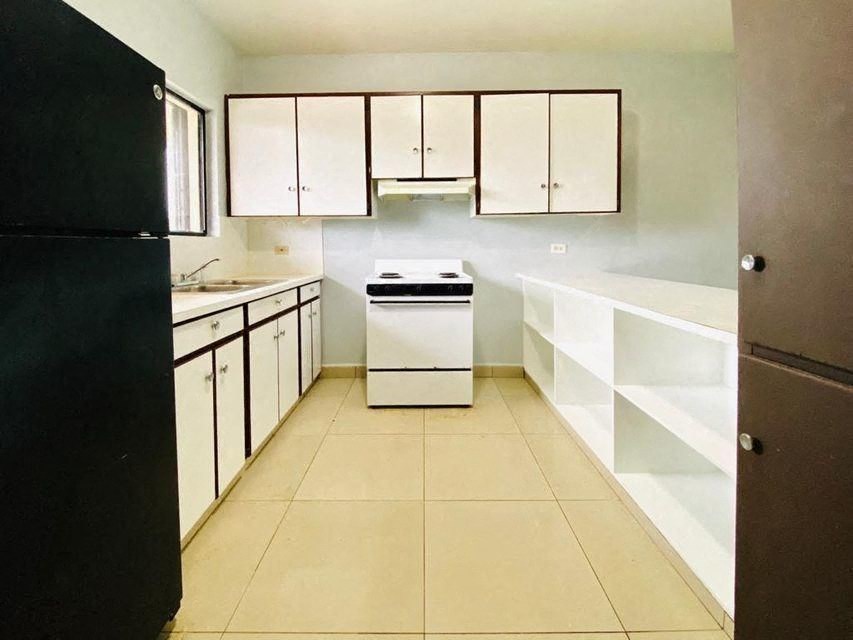 an empty kitchen with a stove and white cabinets