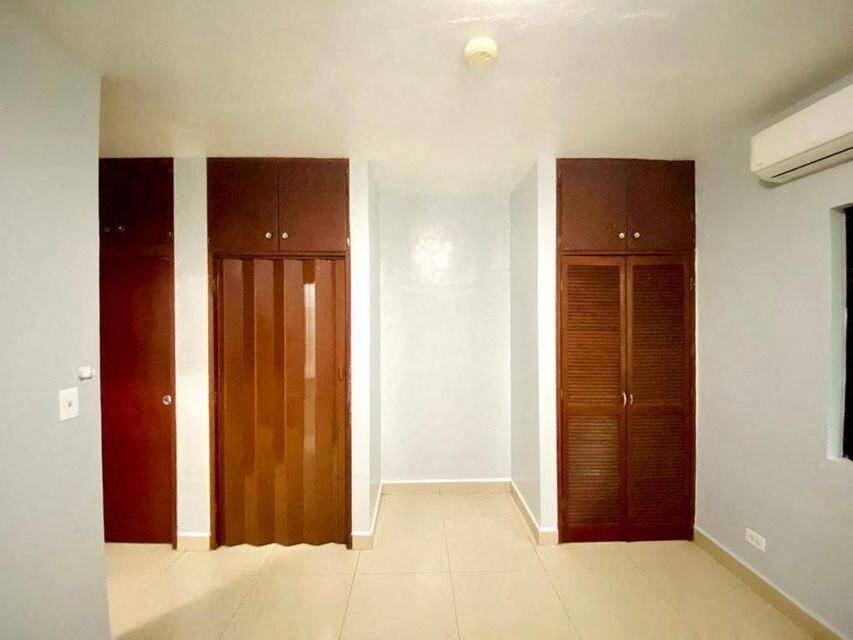 a room with three wooden doors and a white wall