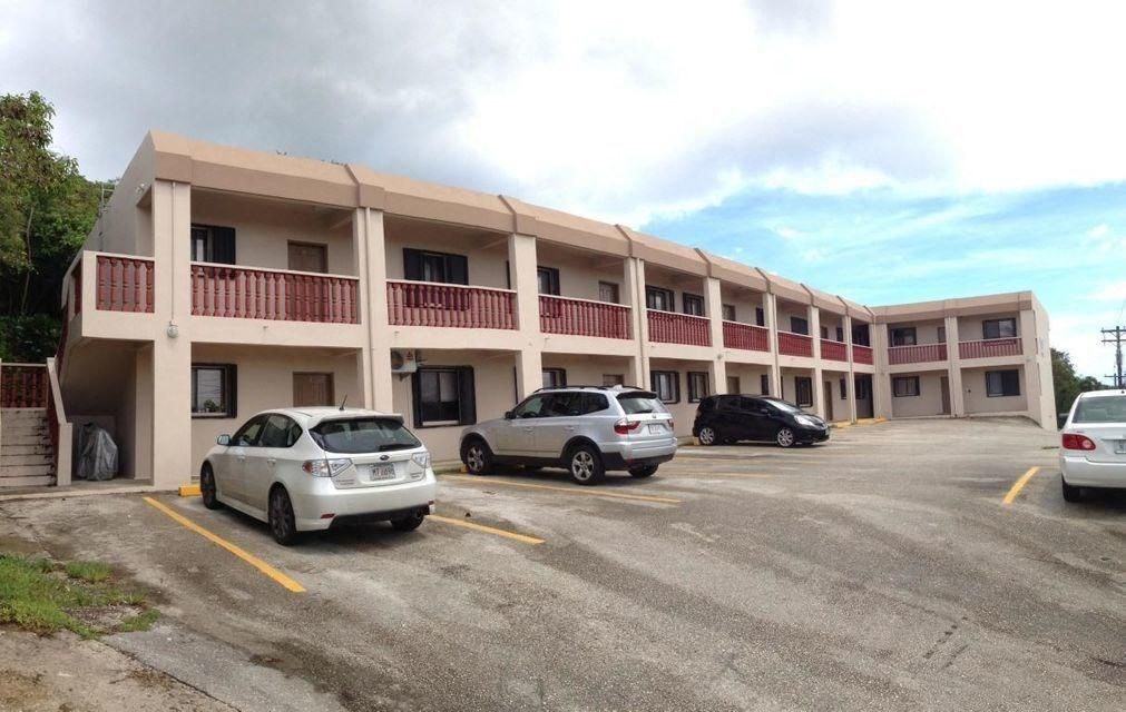 a parking lot in front of an apartment building with cars parked