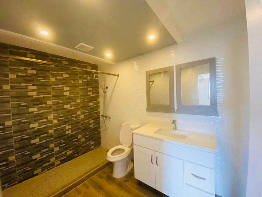 a bathroom with a shower and a toilet and a sink