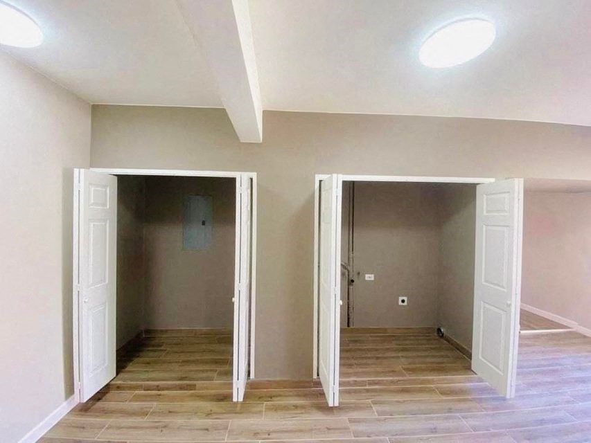 an empty room with three open doors and a wood floor