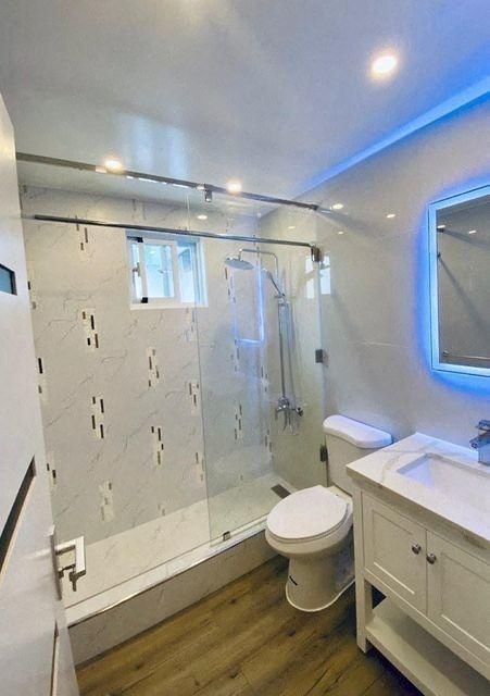 a bathroom with a shower and a toilet and a sink