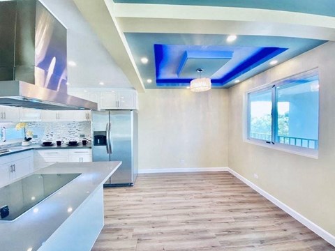 a kitchen with a island and a stainless steel refrigerator