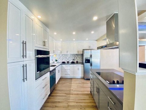 a kitchen with white cabinets and stainless steel appliances