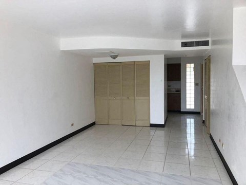 an empty living room with a tile floor and a door