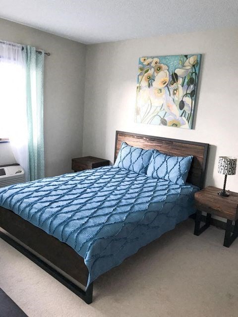 a bedroom with a bed with a blue comforter