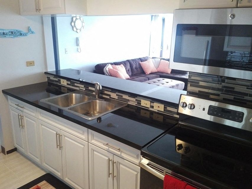 a kitchen with a sink and a stove and a couch