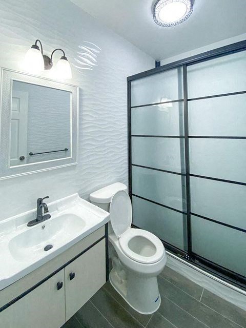 a bathroom with a toilet and a sink and a shower