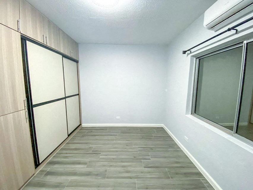 an empty room with a refrigerator and a window