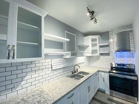 a kitchen with white cabinets and a sink and a stove