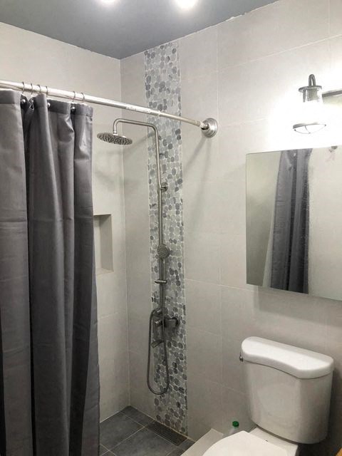 a white bathroom with a shower and a toilet