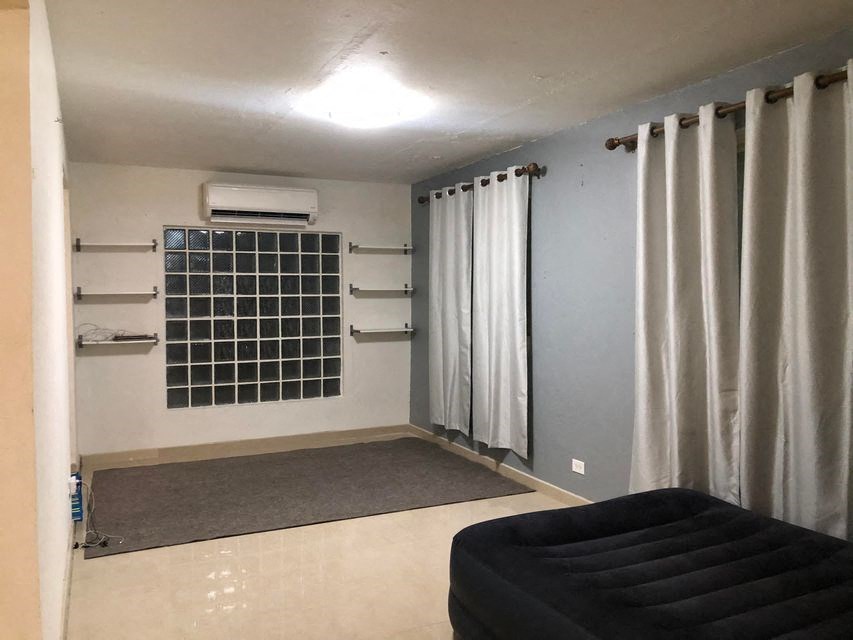 a living room with curtains and a black couch