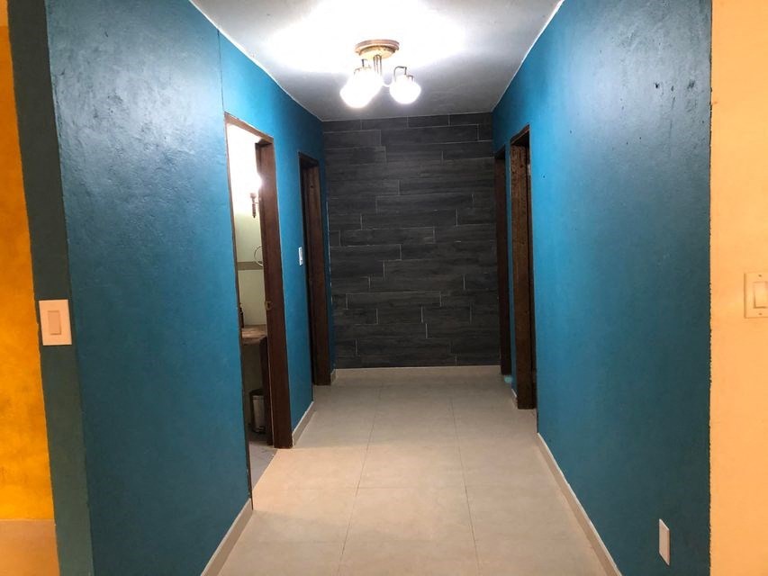 a hallway with blue walls and blue doors and a white tile floor