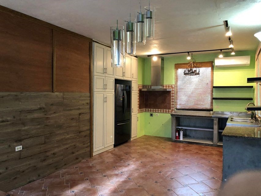 an empty kitchen with green walls and a wooden floor