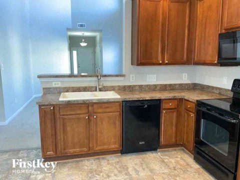 a kitchen with wooden cabinets and black appliances