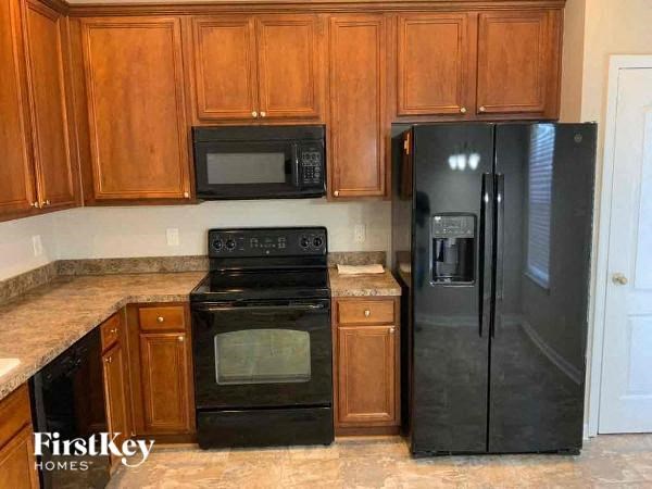 a kitchen with black appliances and wooden cabinets