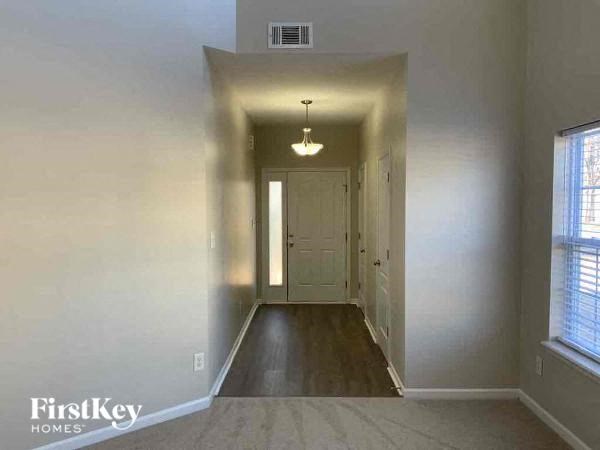 an empty hallway with a white door and window