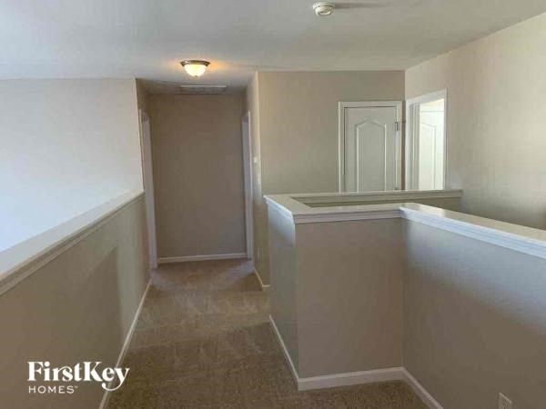 an empty kitchen and hallway with white walls and a white door