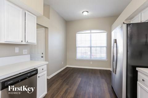 a kitchen with white cabinets and a stainless steel refrigerator