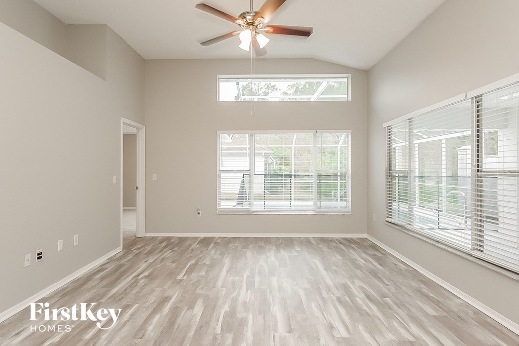 the living room of an empty house with a ceiling fan
