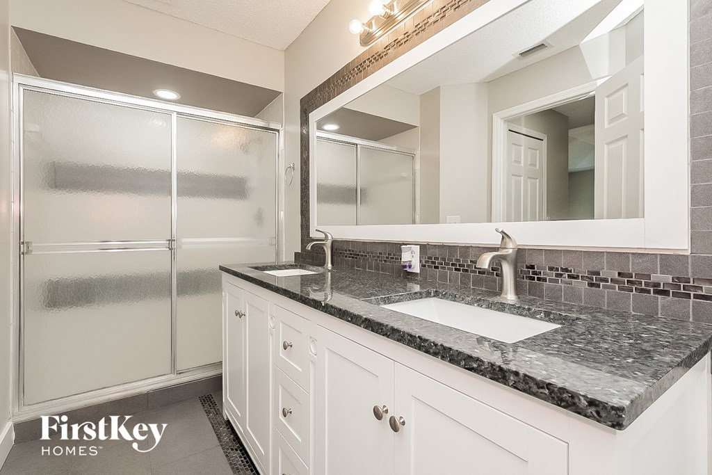 a bathroom with a sink and a mirror and a shower