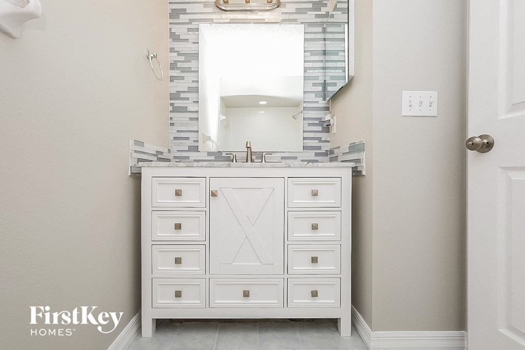 a bathroom with a white vanity and a mirror
