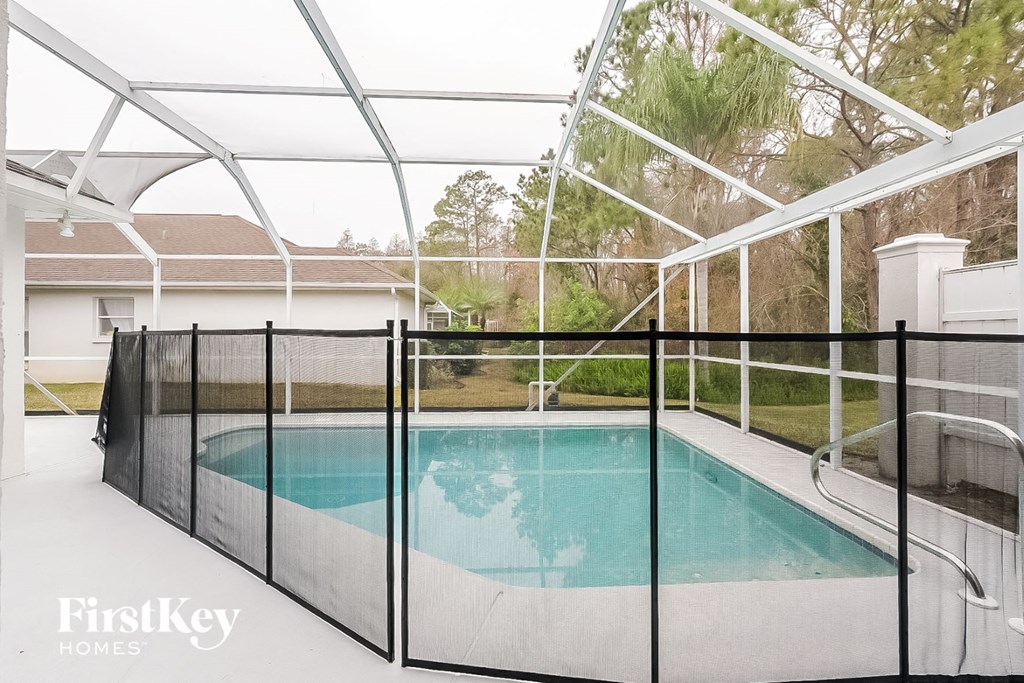 a pool in a screened in porch with a glass fence around it