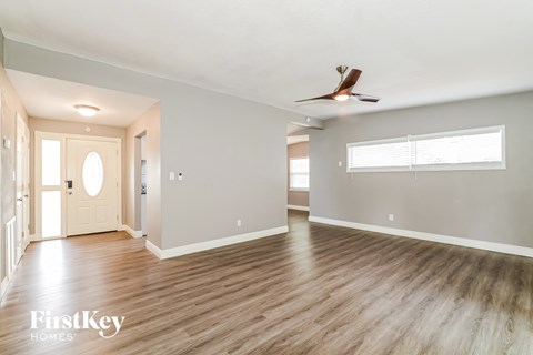 a living room with wood floors and a ceiling fan