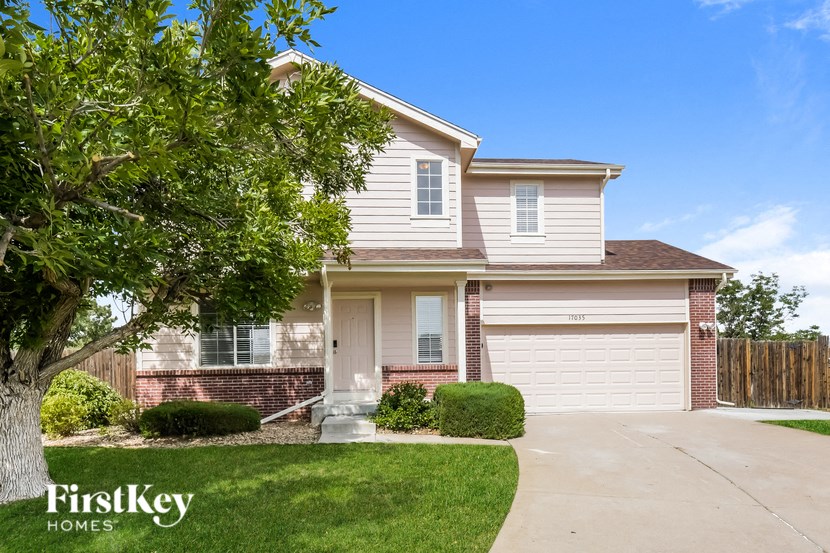 a suburban house with a garage door and a tree