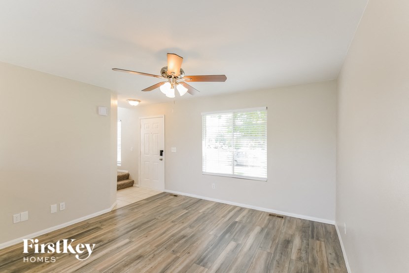 the living room of an empty house with a ceiling fan