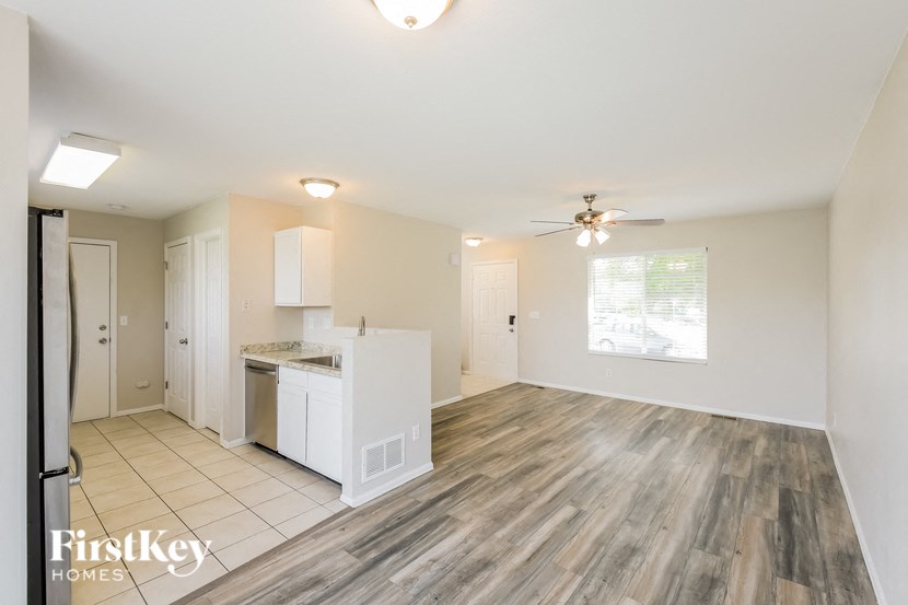 a kitchen and living room with wood flooring and a ceiling fan