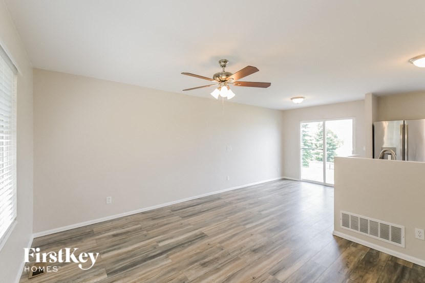 the living room of an empty house with a ceiling fan