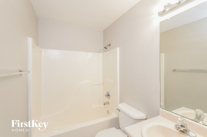 a bathroom with a sink and a tub and a mirror