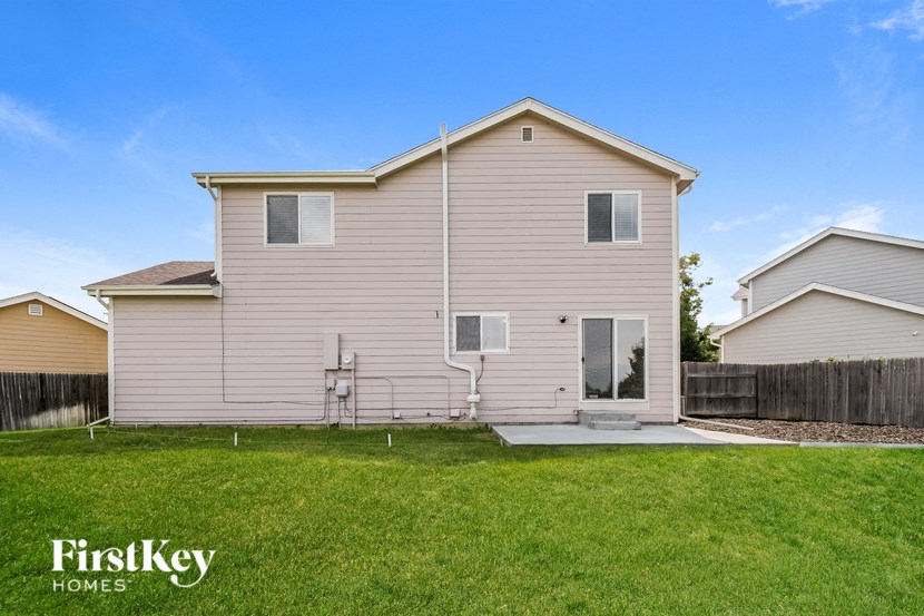 the outside of a house with a grass yard and a fence