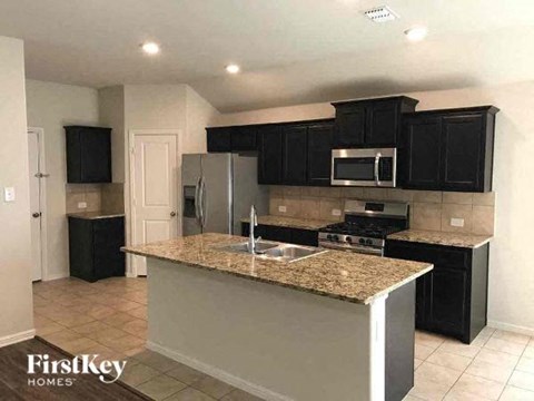 a kitchen with black cabinets and a counter top