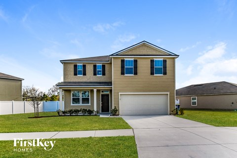 A two-story house with a garage is for sale.