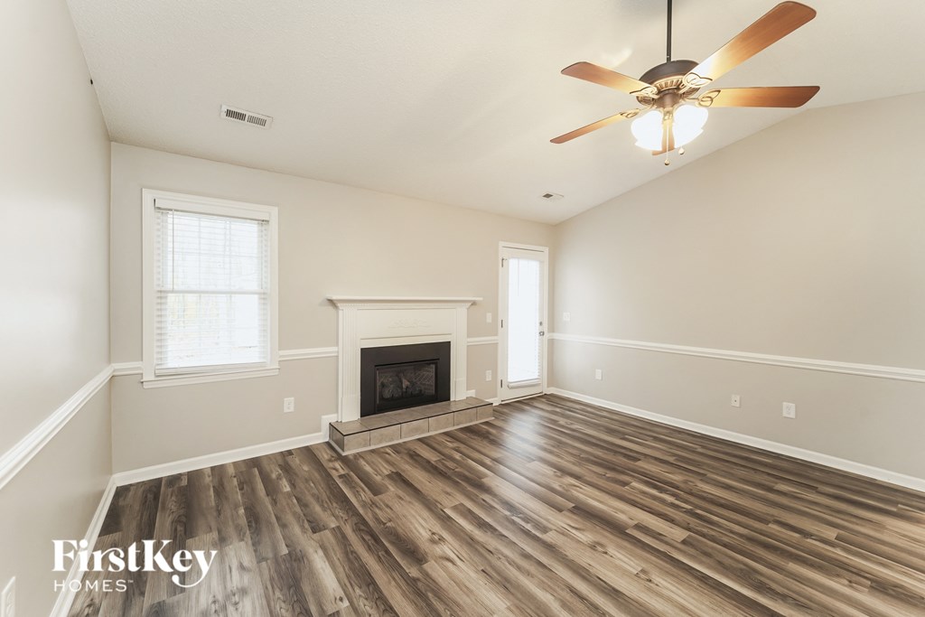 a living room with a fireplace and a ceiling fan