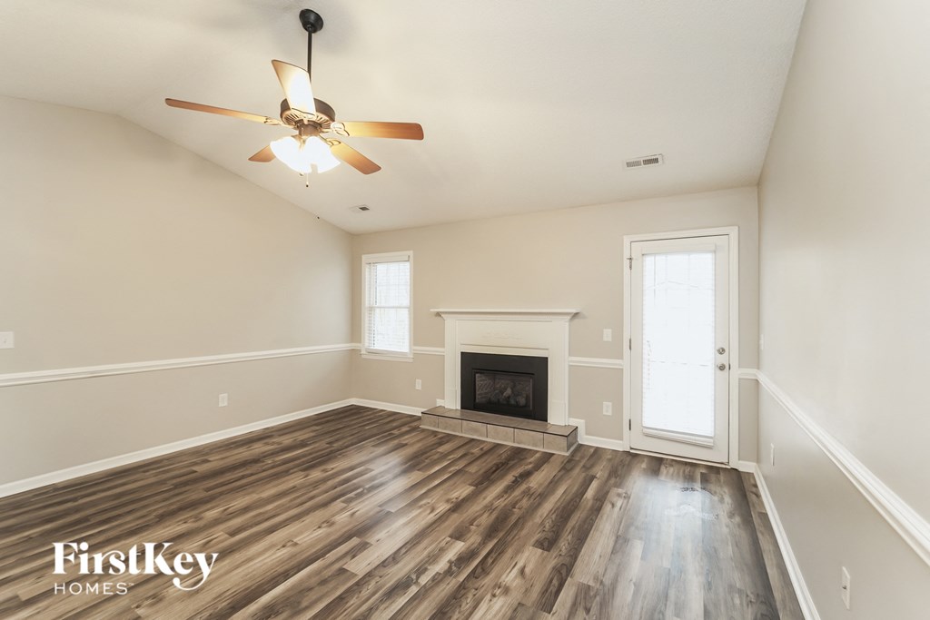 the living room with wood flooring and a fireplace