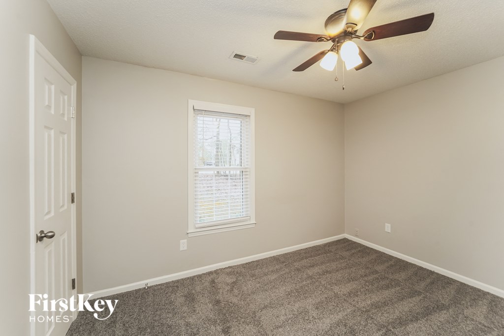 a bedroom with carpet and a ceiling fan